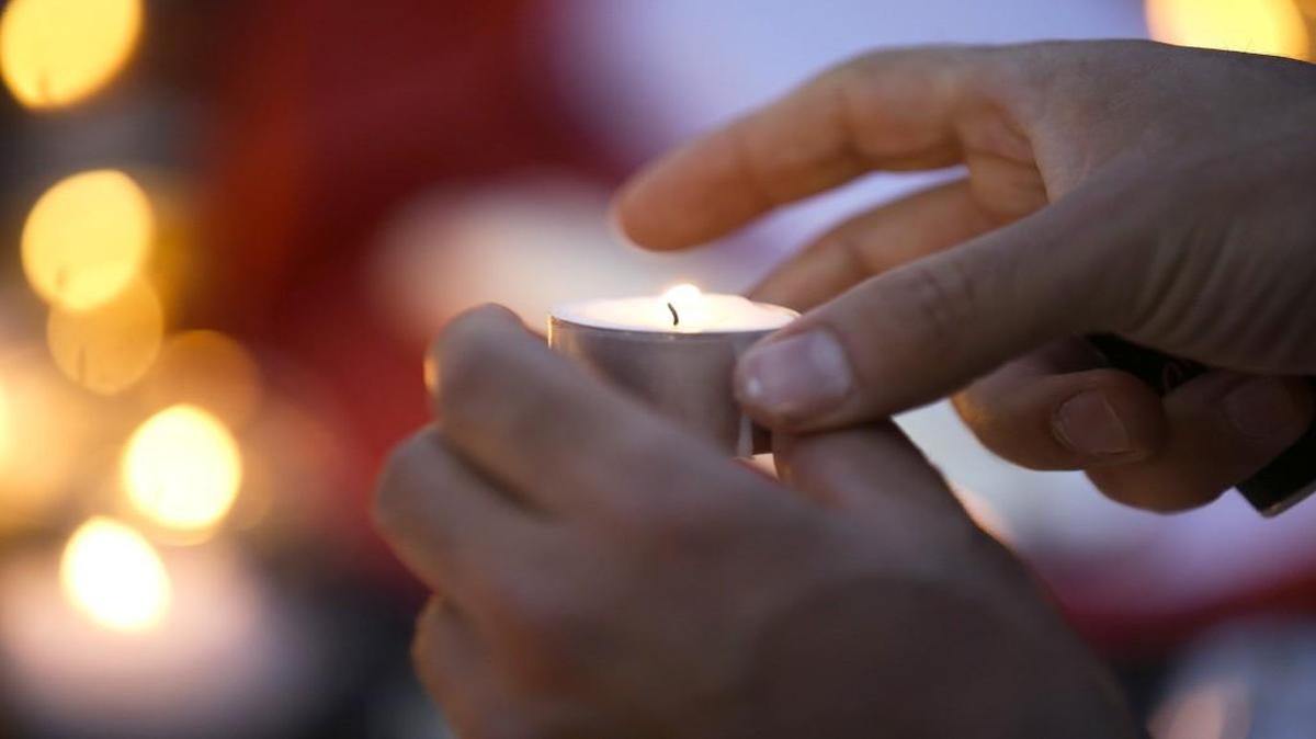 A man lit a candle Friday while paying tribute to the victims of a truck attack in the French resort city of Nice, southern France. A large truck mowed through revelers gathered for Bastille Day fireworks in Nice, killing more than 80 people and sending people fleeing into the sea as it bore down for more than a mile along the Riviera city's famed waterfront promenade.