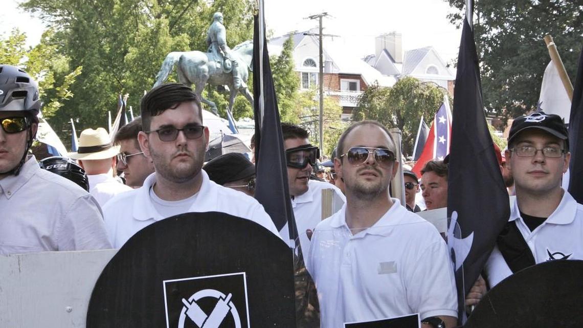 In this Saturday, Aug. 12, 2017 photo, James Alex Fields Jr., second from left, holds a black shield in Charlottesville, Va., where a white supremacist rally took place. Fields was later charged with second-degree murder and other counts after authorities say he plowed a car into a crowd of people protesting the white nationalist rally.