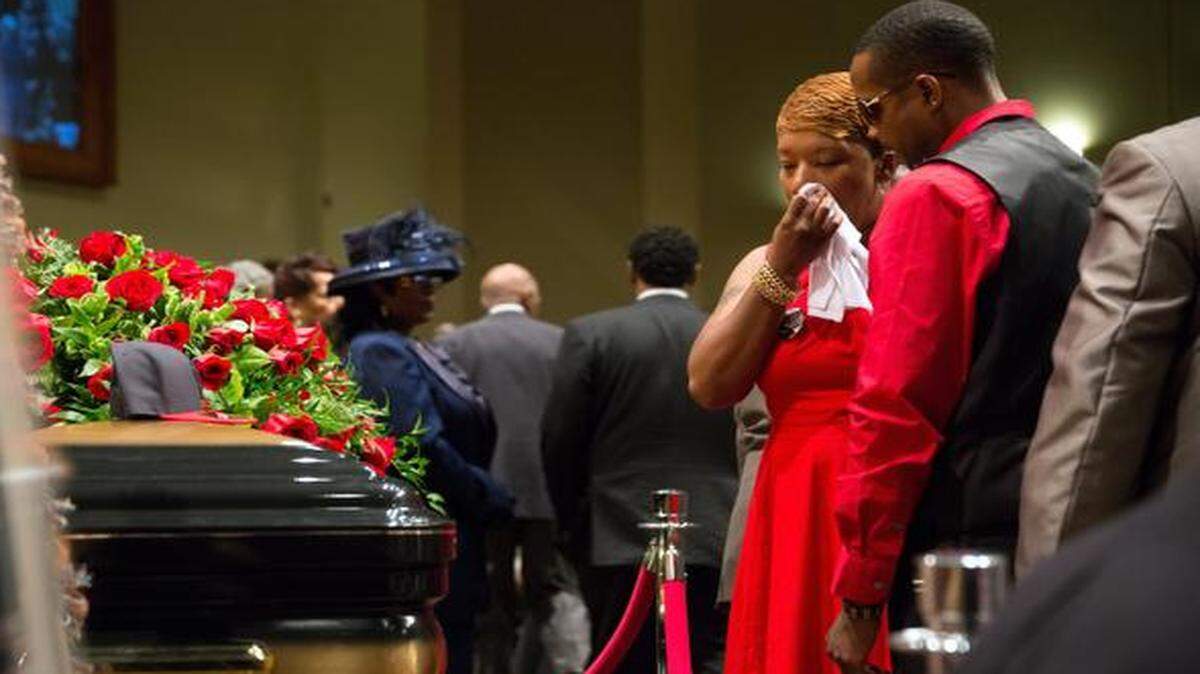 
Lesley McSpadden, mother of Michael Brown, wipes a tear Monday as she stands by his casket at his the funeral at Friendly Temple Missionary Baptist Church in St. Louis. Hundreds of people heard speakers call for unity, peace and justice in the aftermath of Brown’s death. The 18-year-old, unarmed black man was shot and killed Aug. 9 by a Ferguson, Mo., police officer. The more than two weeks since Michael Brown's death have been marked by nightly protests, often violent.
