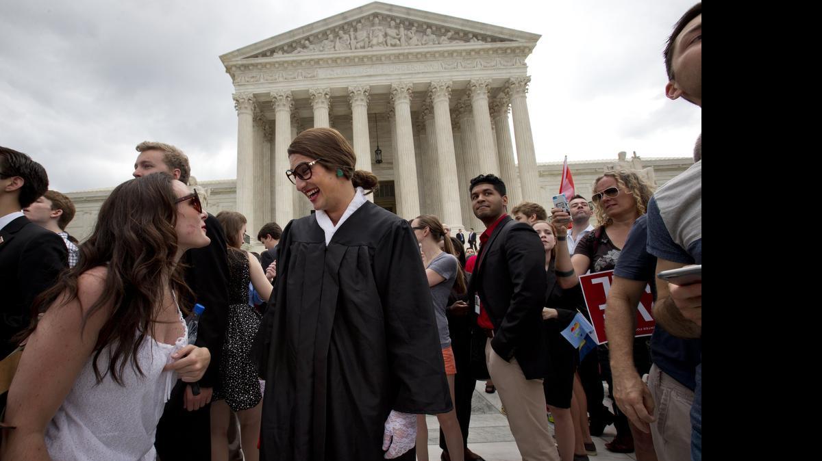 
Joe Goldman, 24, center, is dressed as Supreme Court Justice Ruth Bader Ginsburg outside of the Supreme Court Friday, celebrating the court’s decision that same-sex couples have a right to marry anywhere in the US. 
