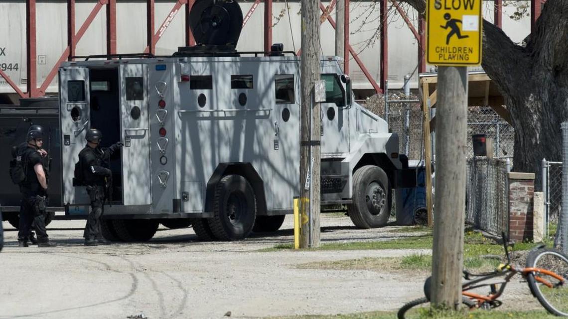 Police stood behind an amored vehicle during a standoff in the East Bottoms in April 2014.