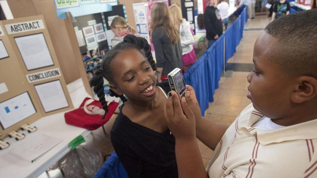 Faxon Elementary School was among public schools participating in a recent science and engineering fair at Union Station. Carlos Liner (right) took a photo of classmate Debonay West. Interim Kansas City superintendent Al Tunis this week pointed to a score of zero in science for the slippage in the district’s annual state performance report.
