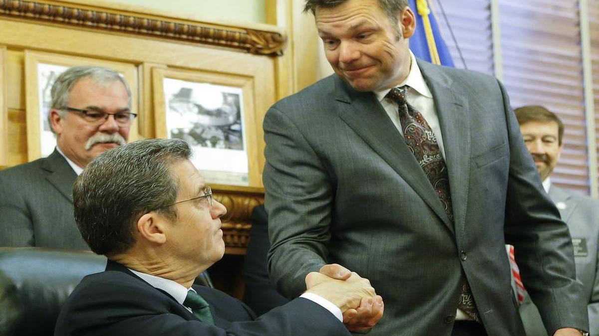
Handshakes were all around after Gov. Sam Brownback signed a bill authorizing Secretary of State Kris Kobach (standing) to prosecute suspected voter fraud.
