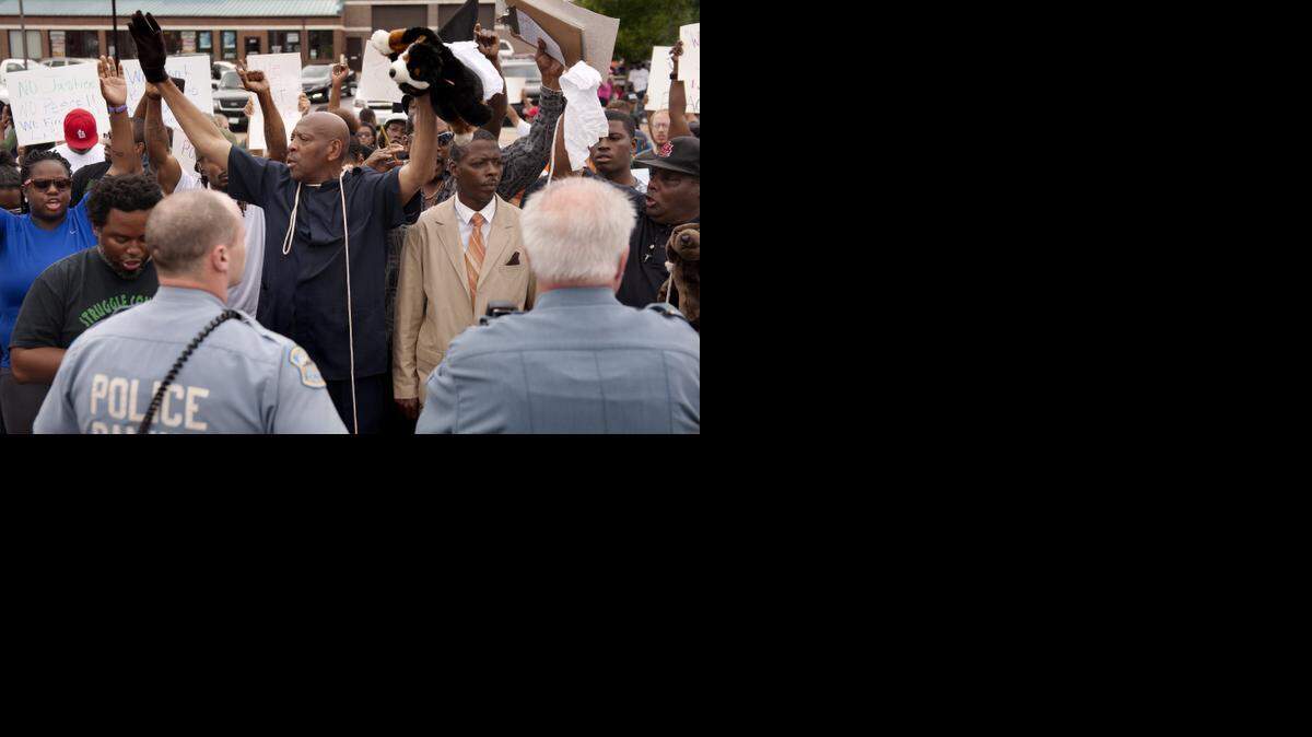 
Protestors raise hands to show solidarity for Michael Brown, 18, who was unarmed when shot by police in Ferguson, Mo.
