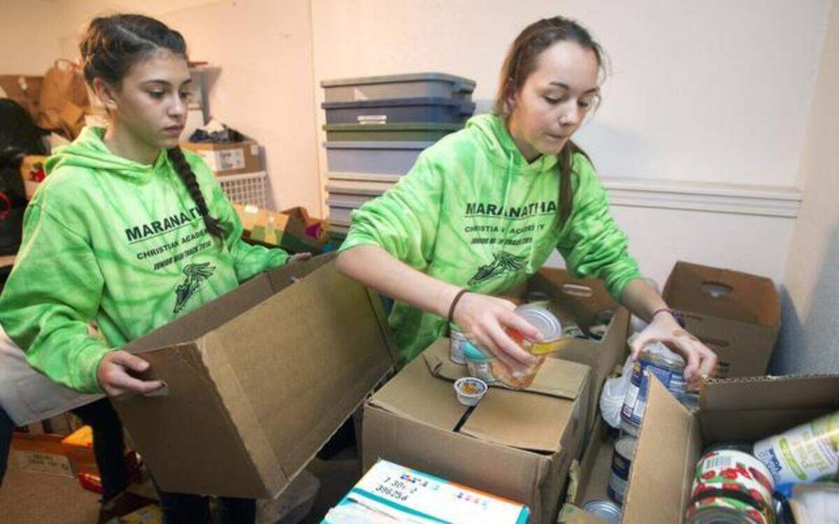 
Students from Maranatha Christian Academy, including Natalie Craig (left) and Natalie Rehfeld, both seventh-graders, sort donated groceries that will be used in BackSnacks for middle school students in need in Olathe and Gardner. 
