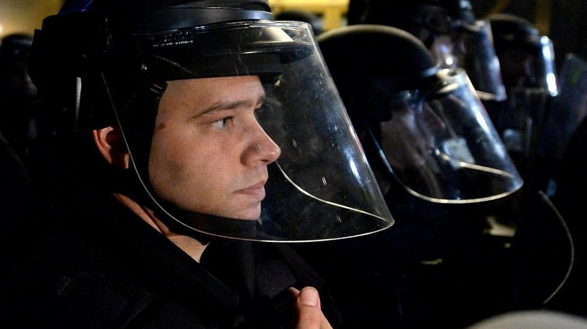 A police officer in riot gear stood with other officers monitoring protesters Thursday night in Charlotte, N.C., following the police-involved shooting death of Keith Scott.