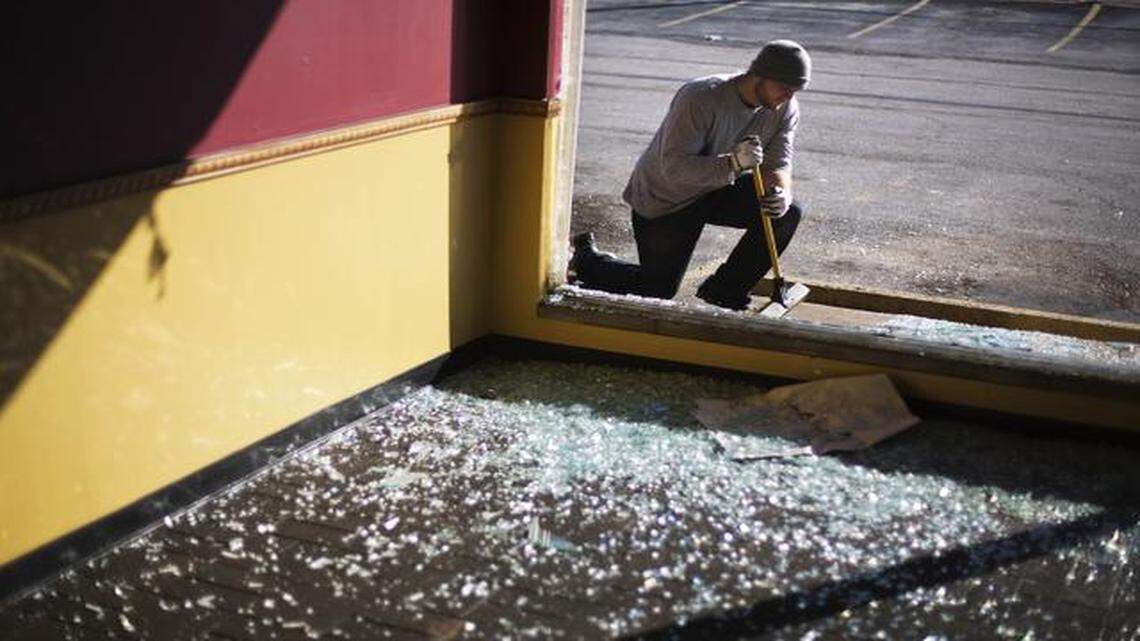 
Brock Alsept paused while sweeping up glass in front of a store damaged in Monday night’s riot in Ferguson, Mo.
