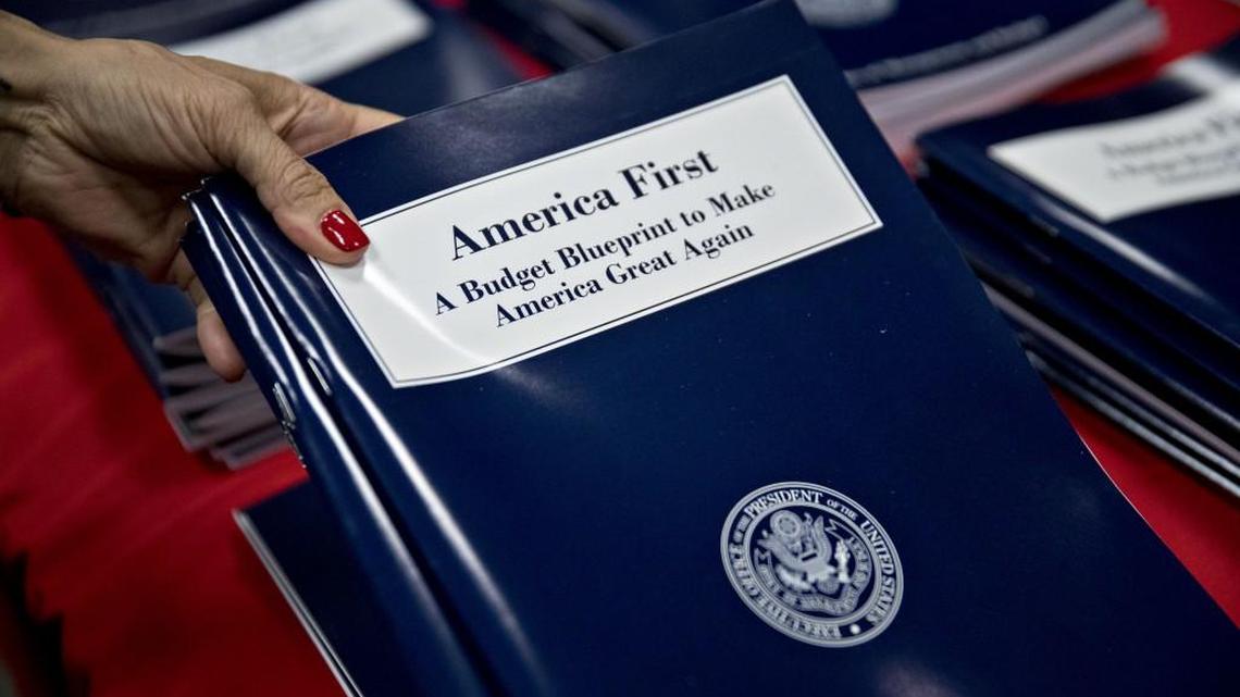 An employee arranges copies of U.S. President Donald Trump's fiscal 2018 budget request, America First: A Budget Blueprint to Make America Great Again.