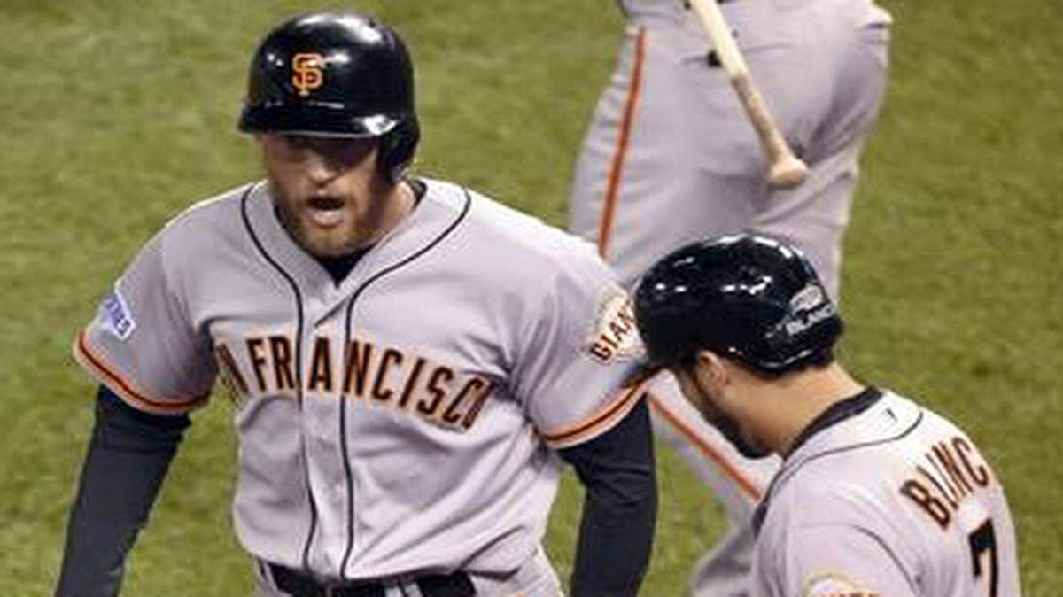 
Giants shortstop Brandon Crawford (right) greeted right fielder Hunter Pence after Pence scored on a sacrifice fly in the first inning to give the Giants a 2-0 lead in game seven of the World Series on Wednesday night at Kauffman Stadium.
