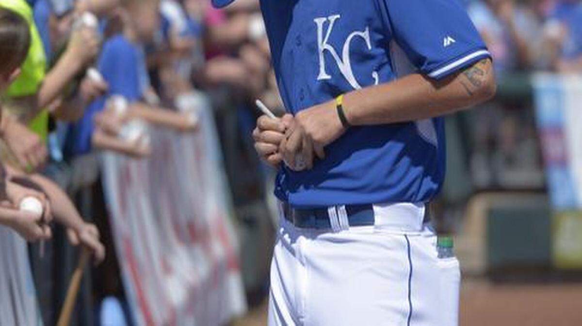 
Royals pitcher Aaron Brooks signs a baseball for a fan before Saturday's spring training game against the Angels in Surprise, Ariz.
