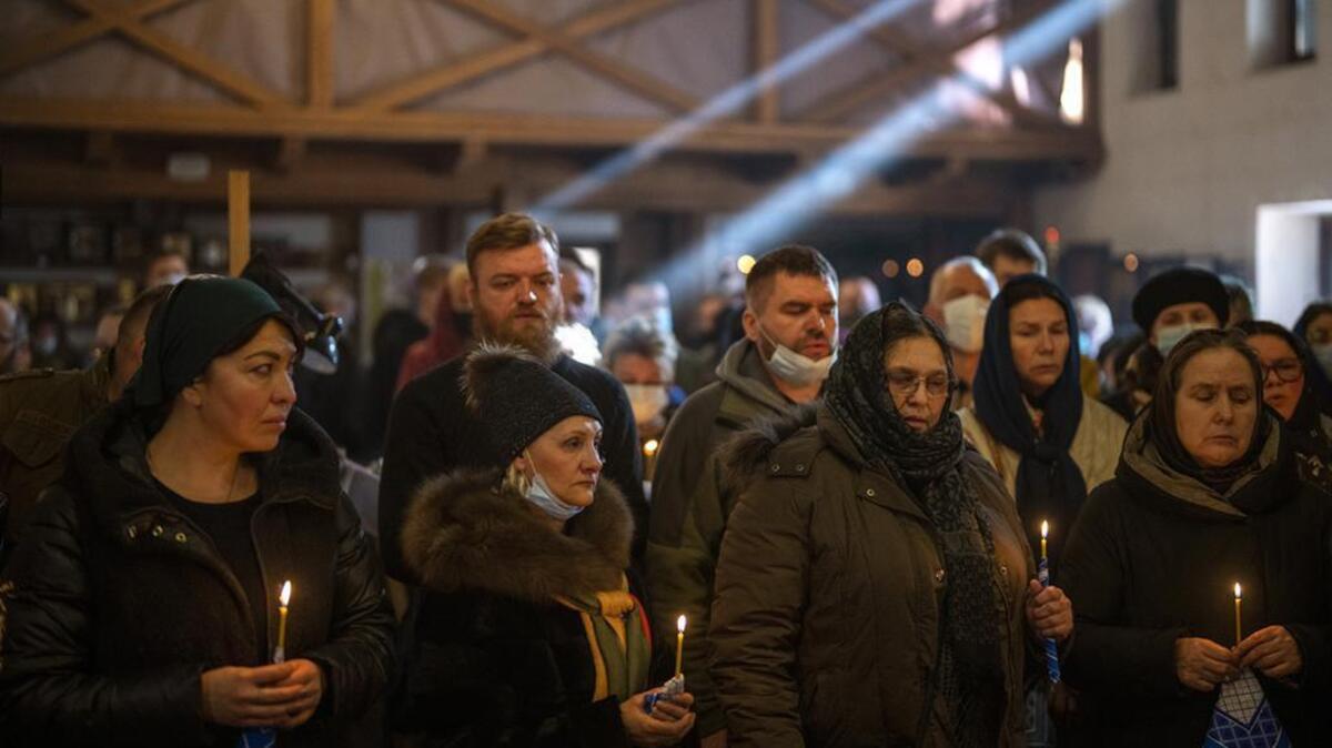 People pray next to the body of Ukrainian Army captain Anton Sydorov, 35, killed in eastern Ukraine, during his funeral in Kyiv, Ukraine, last week.