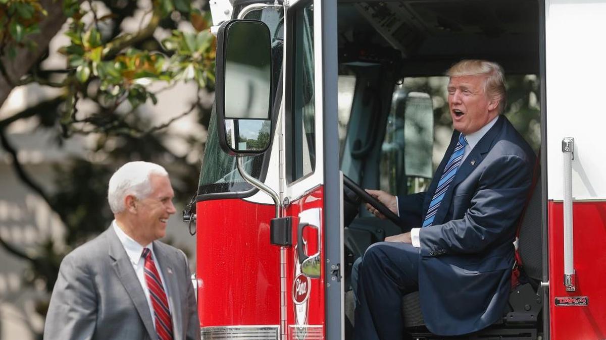 President Donald Trump, accompanied by Vice President Mike Pence, sits inside a cabin of a firetruck during a “Made in America” product showcase Monday.