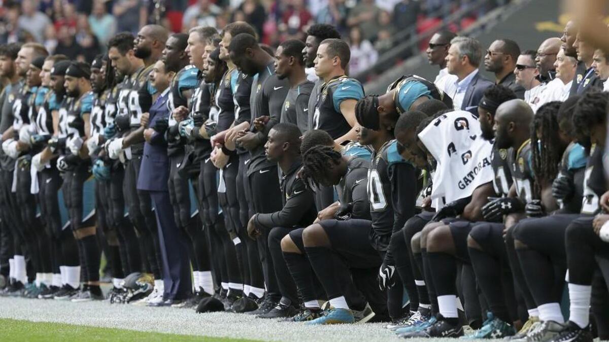 Jacksonville Jaguars players lock arms and kneel during the playing of the U.S. national anthem at Wembley Stadium in London Sunday.