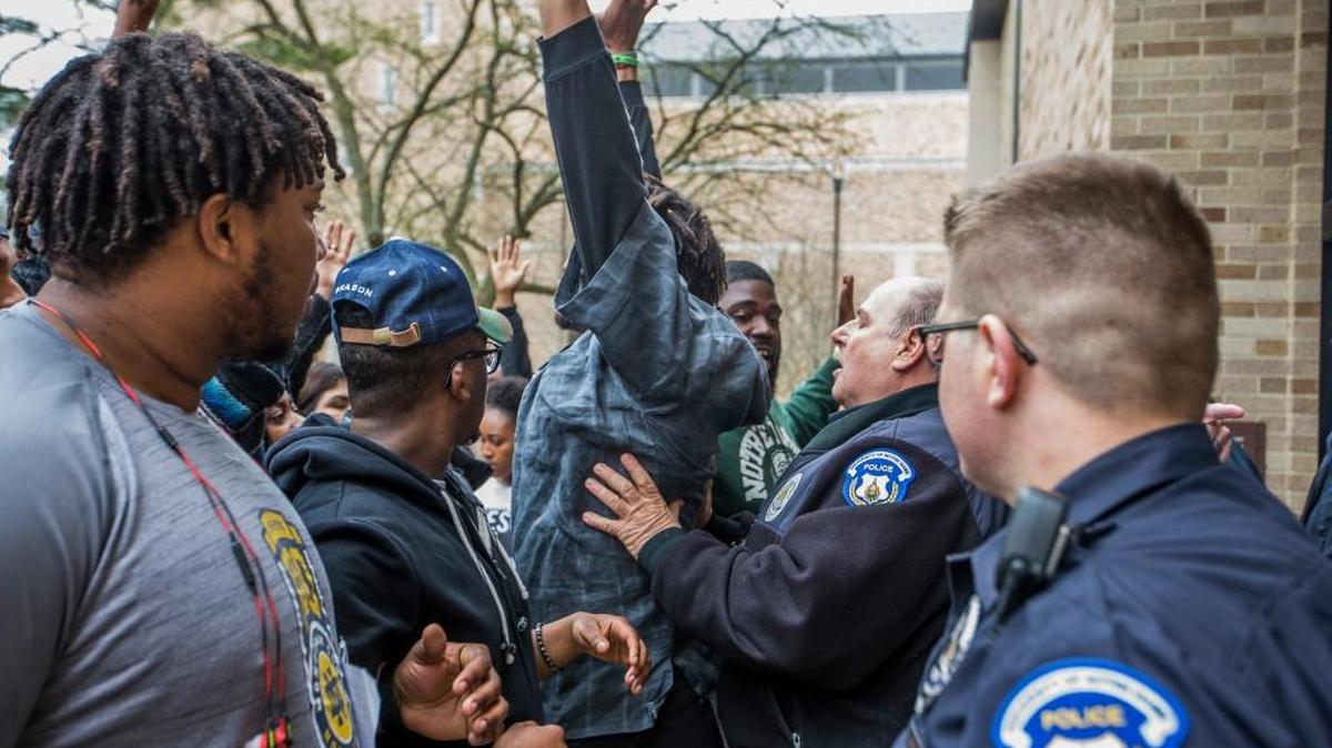 A police officer pushes back Notre Dame senior Doug Randolph, a former Notre Dame football player, as students protest an event featuring Charles Murray, a controversial conservative speaker, writer and academic, Tuesday, March 28, 2017, on the campus of the University of Notre Dame in South Bend, Ind.