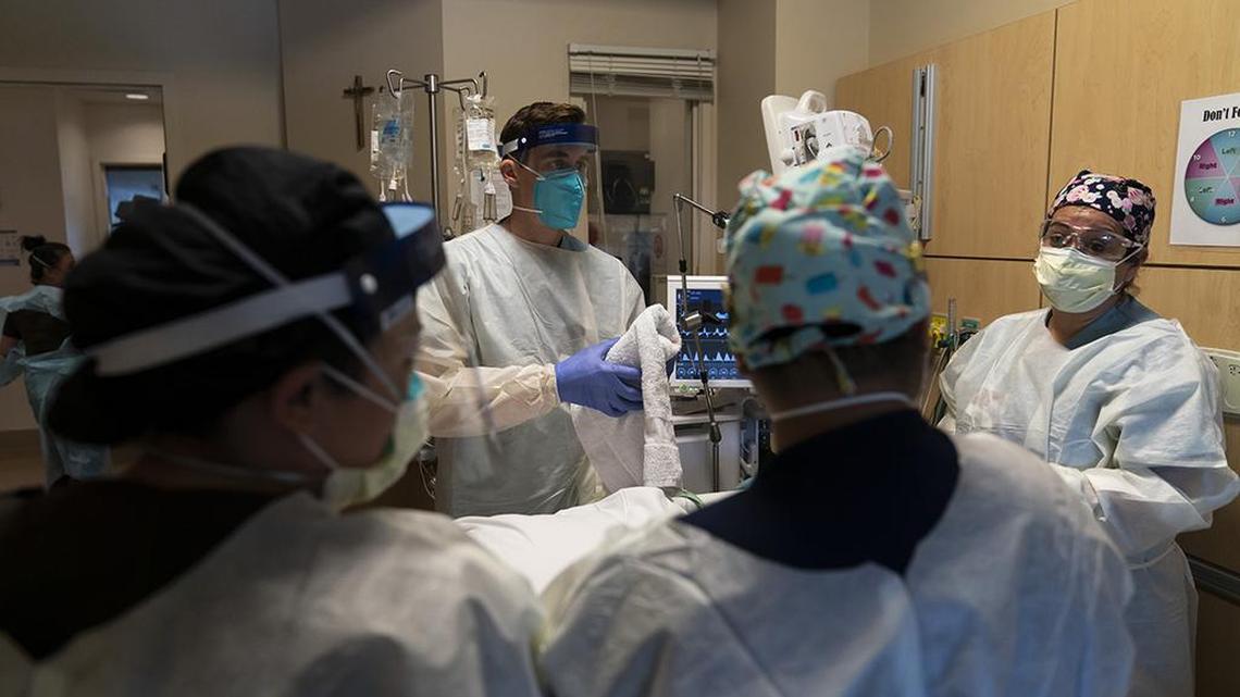 FILE - In this Nov. 19, 2020, file photo, medical personnel prepare to prone a COVID-19 patient at Providence Holy Cross Medical Center in the Mission Hills section of Los Angeles. California is desperately searching for nurses, doctors and other medical staff, perhaps from overseas, to meet demands as the coronavirus surge pushes hospitals across the state to the breaking point. With many of the state’s hospitals running out of capacity to treat the severest cases, the state has brought in and deployed more than 500 extra staff but it needs a total of 3,000 temporary medical staff members. (AP Photo/Jae C. Hong)