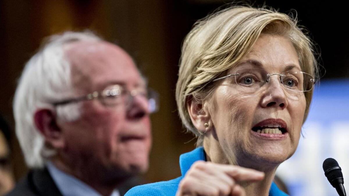 In this 2017 file photo, Sen. Elizabeth Warren speaks as Sen. Bernie Sanders listens during a news conference.