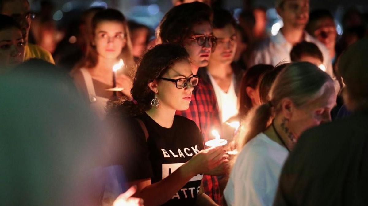People in support of the removal of Confederate monuments hold candles during a counter-protest against those gathered to call on officials to halt the removal of a Gen. Robert E. Lee statue in Charlottesville, Va., Sunday, May 14, 2017.