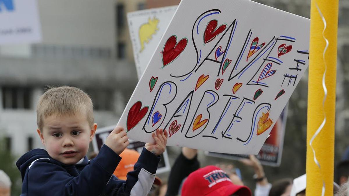 A young boy holds a sign during an anti-abortion rally on the steps of the Capitol in Richmond, Va., Thursday, Feb. 7, 2019. (AP Photo/Steve Helber)