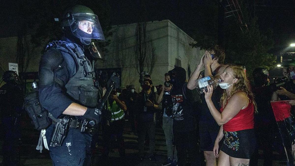 Police guard as protesters take to the streets in Portland, Ore in 2020. Portland saw massive unrest during protests over the May 25 police killing of George Floyd. (AP Photo/Paula Bronstein)