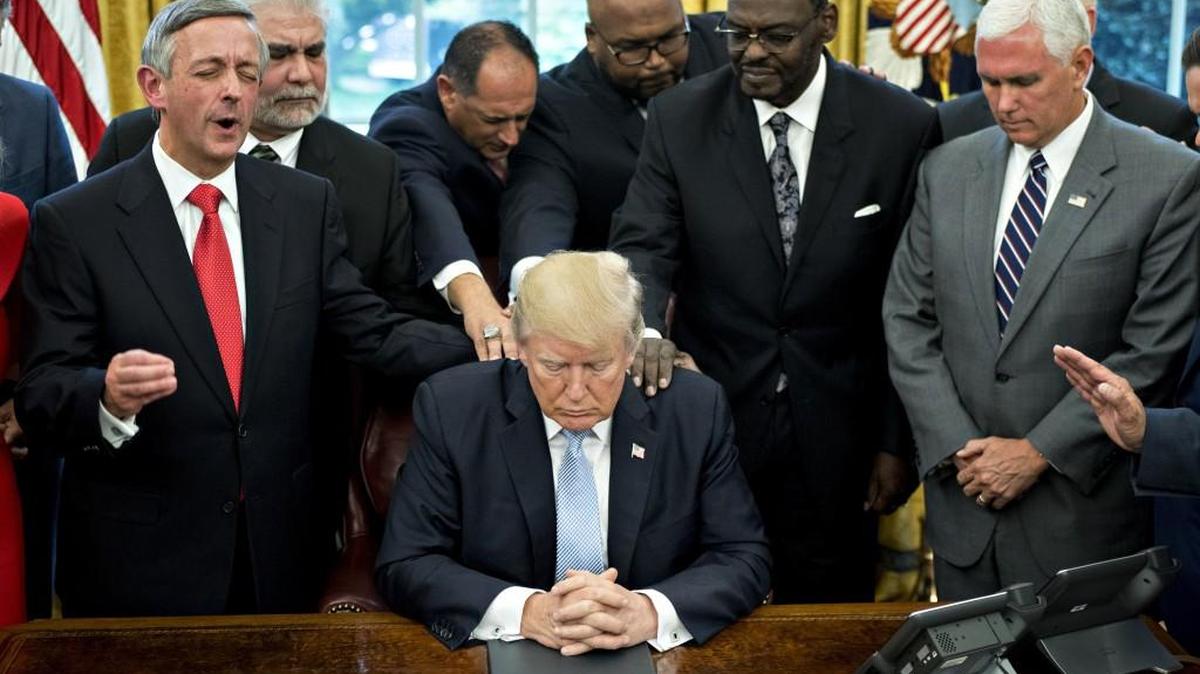 President Donald Trump, center, bows his head during a prayer while surrounded by U.S. Vice President Mike Pence, right, faith leaders and evangelical ministers in 2017. Paul Prather says you can look for “real Christians” in more humble scenarios than politics.