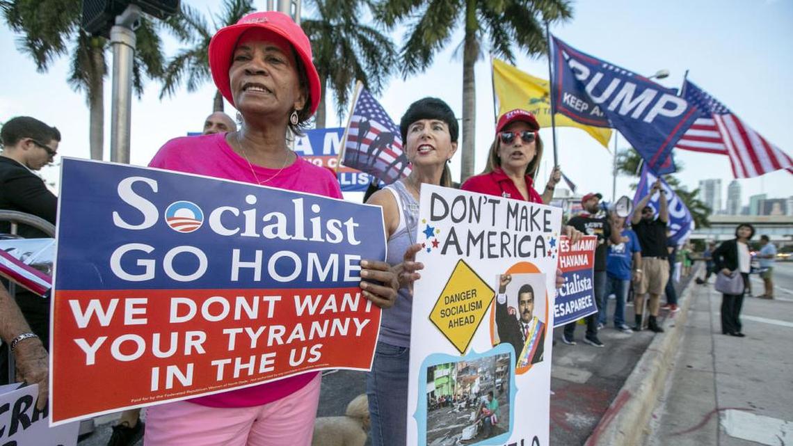 Supporters of President Donald Trump Linda, left, and Mina, right, chant “USA” as they hold signs condemning socialist practices, outside of the Adrienne Arsht Center before the first Democratic Debates, in Miami, Florida on Wednesday June 26, 2019.