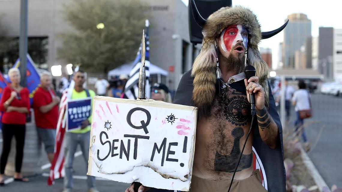 FILE - In this Nov. 5, 2020, file photo, Jacob Anthony Chansley, who also goes by the name Jake Angeli, a Qanon believer speaks to a crowd of President Donald Trump supporters outside of the Maricopa County Recorder’s Office where votes in the general election are being counted, in Phoenix. In its annual report set to be released Monday, Feb. 1, 2021, the Southern Poverty Law Center said it identified 838 active hate groups operating across the U.S. in 2020. (AP Photo/Dario Lopez-Mills, File)