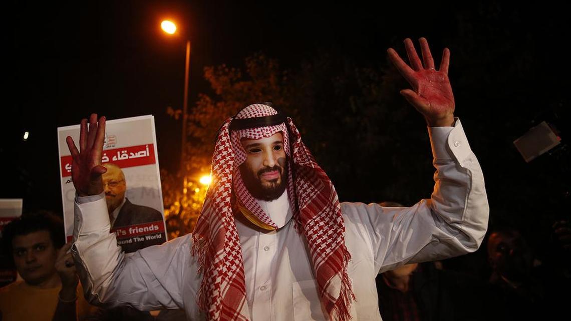 An activist wearing a mask depicting Saudi Crown Prince Mohammed bin Salman, holds up his hands painted with fake blood during a candlelight vigil for Saudi journalist Jamal Khashoggi outside Saudi Arabia’s consulate in Istanbul on Oct. 25.