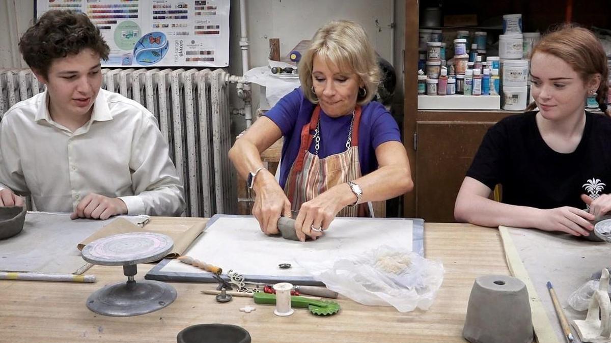 U.S. Secretary of Education Betsy DeVos formed a clay bowl under the supervision of Kansas City Academy students Spencer Weis (left) and Claire Kovzan on Friday, Sept. 15, 2017, during a tour of the school.