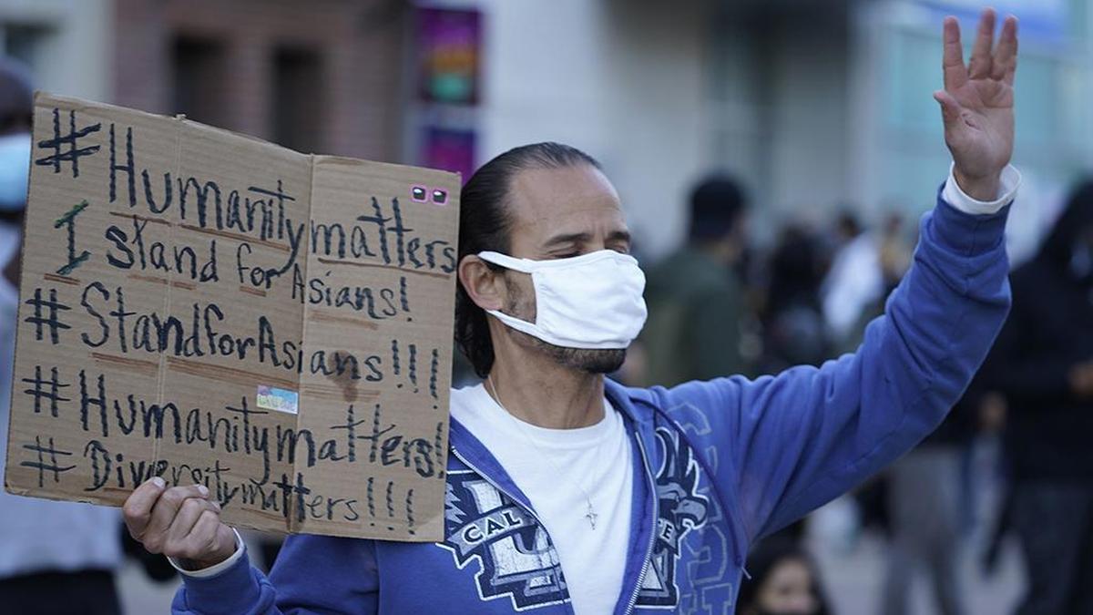 A man participates in the rally “Love Our Communities: Build Collective Power” to raise awareness of anti-Asian violence outside the Japanese American National Museum in Little Tokyo in Los Angeles Saturday, March 13, 2021. Los Angeles County officials are stepping up their efforts to battle hate crimes against Asian Americans. The “LA vs. Hate” initiative encourages people to call 211 if they are victims or witness an incident of hate. (AP Photo/Damian Dovarganes)