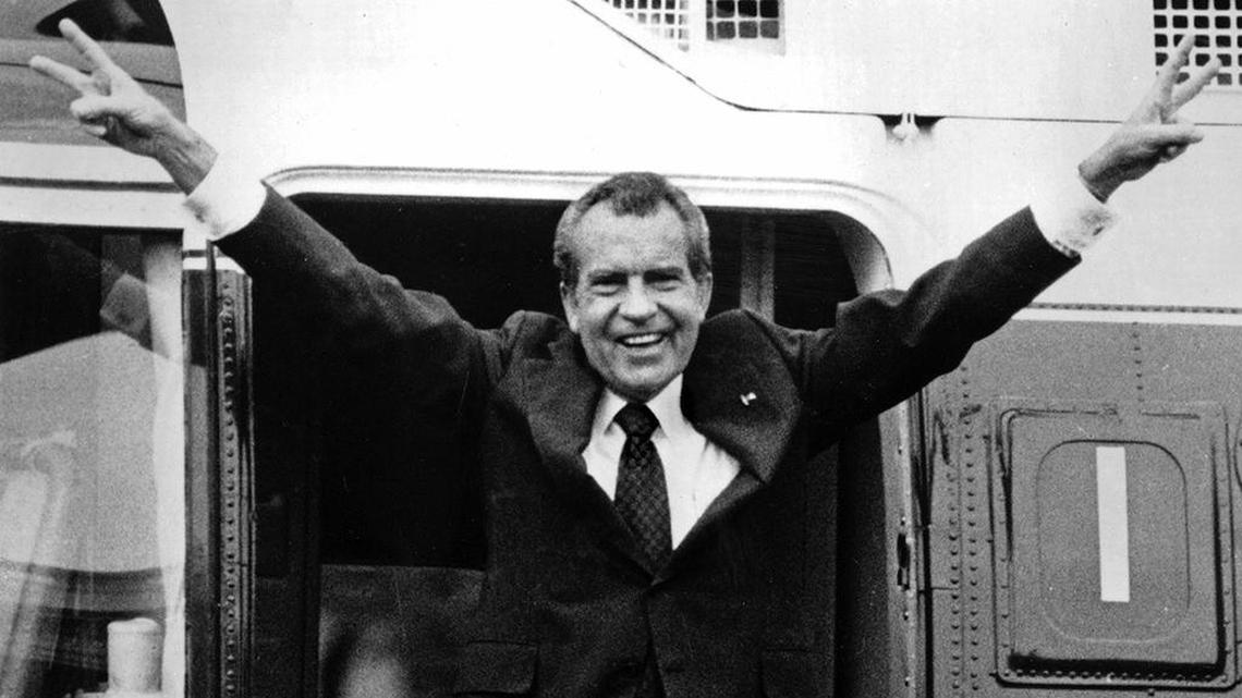 In this Aug. 9, 1974 file photo, Richard Nixon waves goodbye with a salute to his staff members outside the White House as he boards a helicopter after resigning the presidency.