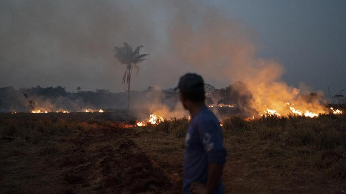 Neri dos Santos Silva watches an encroaching fire threat after digging trenches to keep the flames from spreading to the farm he works on, in the Nova Santa Helena municipality, in the state of Mato Grosso, Brazil, Friday, Aug. 23, 2019. Under increasing international pressure to contain fires sweeping parts of the Amazon, Brazilian President Jair Bolsonaro on Friday authorized use of the military to battle the massive blazes. (AP Photo/Leo Correa)