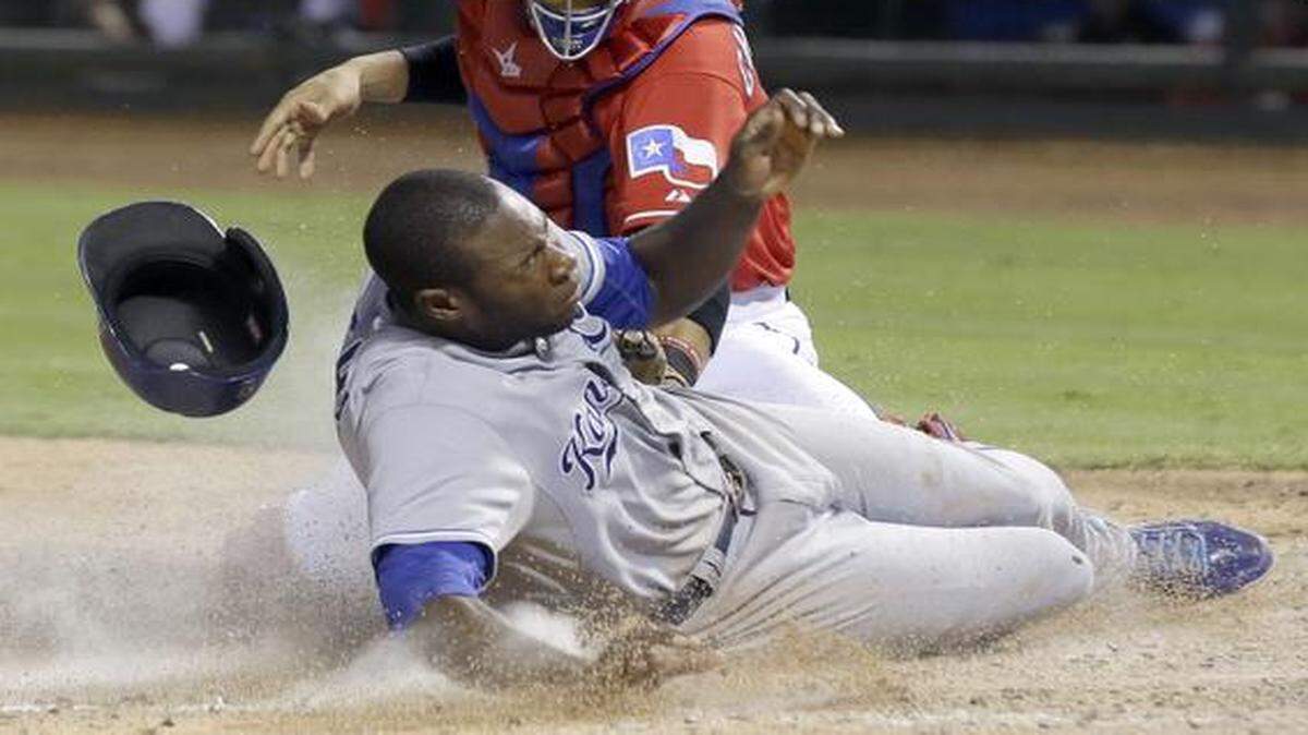 
The Kansas City Royals’ Lorenzo Cain (bottom) scored against Texas Rangers catcher Robinson Chirinos during the seventh inning on Saturday in Arlington, Texas. Cain scored on a single by Jarrod Dyson. 
