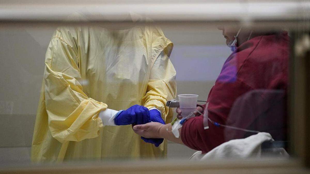 Registered nurse Chrissie Burkhiser, left, hands medication to a COVID-19 patient inside the emergency room at Scotland County Hospital Tuesday, Nov. 24, 2020, in Memphis, Mo. The tiny hospital in rural northeast Missouri is seeing an alarming increase in coronavirus cases. (AP Photo/Jeff Roberson)