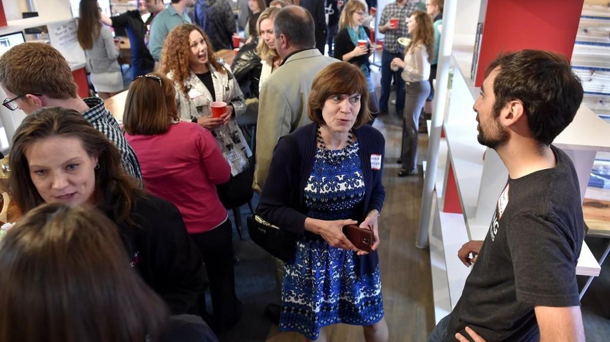 Adam Arredondo (far right), one of the Village Square startup founders, visited with Maria Meyers of KCSourceLink at a 2015 entrepreneur open house.