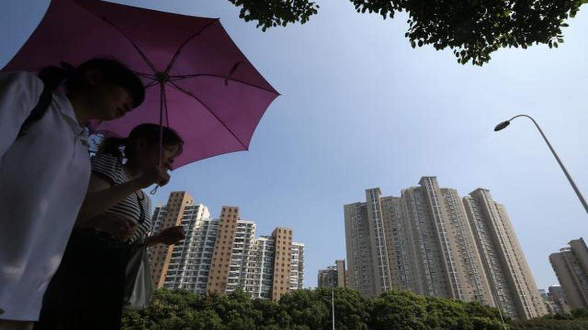 
Women holding an umbrella walked past residential buildings in Shanghai, China. 
