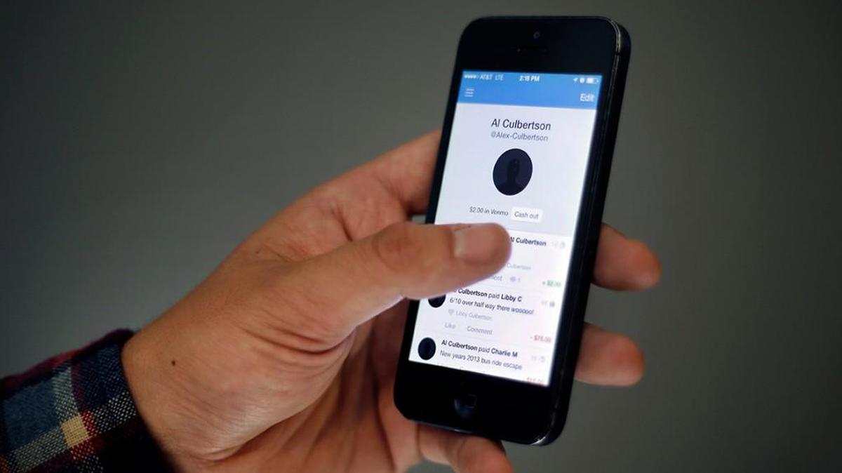 In this June 19, 2015 photo, Alex Culbertson, 26, shows transactions via the Venmo app on his smartphone, Friday, June 19, 2015, in Boston. On a recent trip to Maine with six friends, Culbertson had to split up a weekend tab of gas, hotel rooms, food and drink. One person paid for everything and they split the final result, via Venmo, the PayPal-owned app that lets users pay with a tap and a text-like message.. (AP Photo/Elise Amendola)