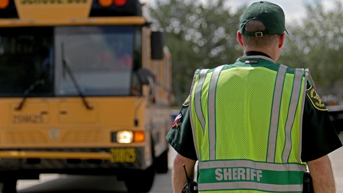 A deputy with the Broward County Sheriff's Office directs traffic outside of Marjory Stoneman Douglas High School in Parkland, Fla. on Monday, April 2, 2018.