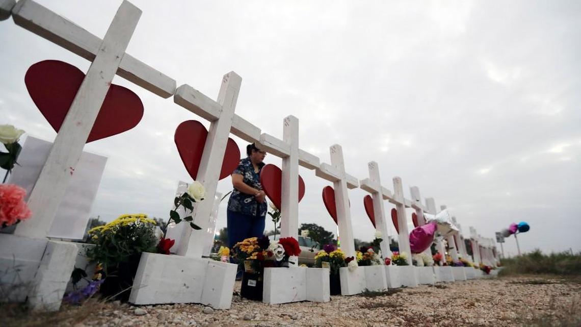 A woman visits a makeshift memorial along the highway for the victims of the church shooting at Sutherland Springs Baptist Church, Friday in Sutherland Springs, Texas.