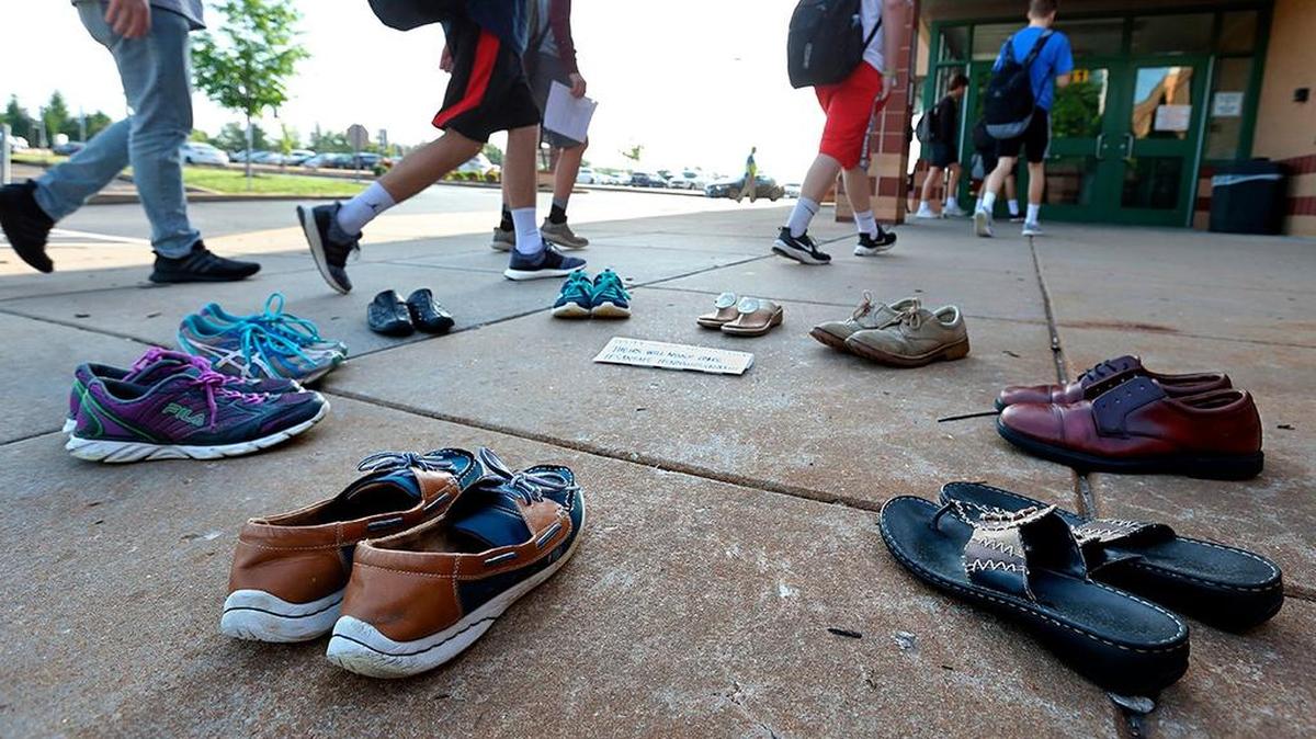 Lafayette High School in Wildwood, Mo., students walk past a memorial to victims of the Santa Fe High School shooting on their way to class on May 22, 2018.