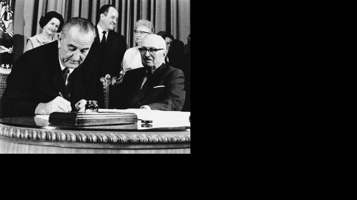 
President Lyndon Johnson (left) signed the Medicare bill into law on July 30, 1965, while former president Harry S. Truman watched during a ceremony at the Truman Library in Independence.
