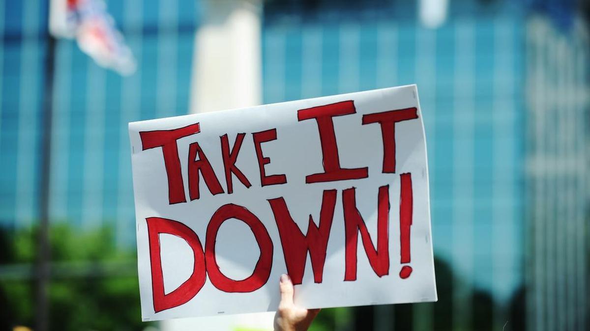 
Protesters held signs during a rally Tuesday to remove the Confederate flag at the statehouse in Columbia, S.C.
