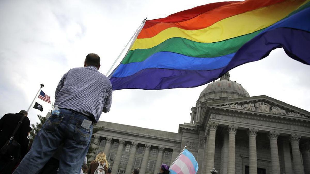 In this March 2016, file photo, gay-rights supporter Mathew “Skippy” Mauldin holds a flag during a rally outside the Capitol in Jefferson City. (AP Photo/Jeff Roberson, File)