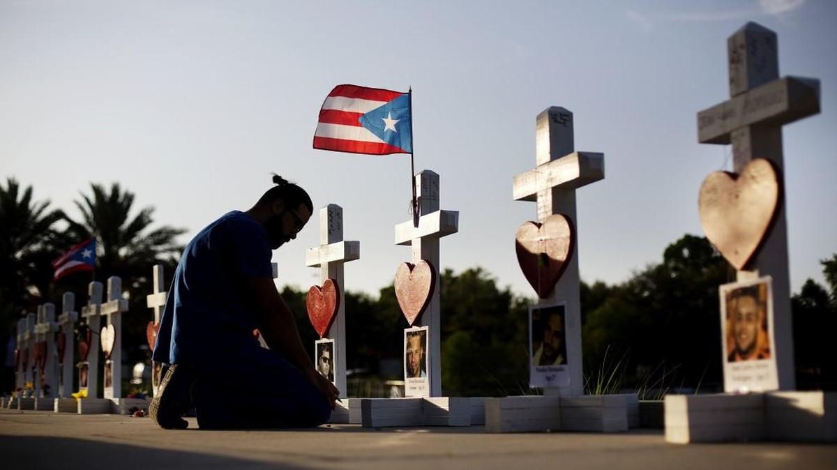 Ernesto Vergne prays at a cross honoring his friend Xavier Emmanuel Serrano Rosado and the other victims at a memorial to those killed in the Pulse nightclub mass shooting a few blocks from the club early Friday, June 17, 2016, in Orlando, Fla.