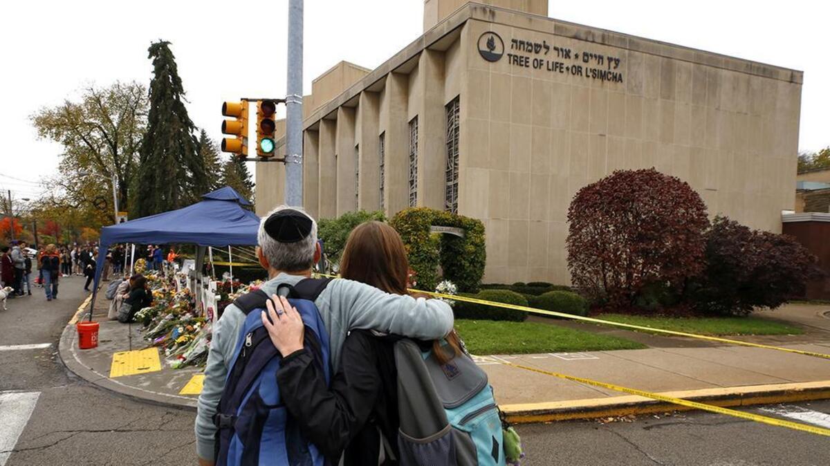 People pay their respects Thursday, Nov. 1, 2018, at a makeshift memorial outside the Tree of Life Synagogue to the 11 people killed Oct 27, 2018 while worshipping in the Squirrel Hill neighborhood of Pittsburgh. (AP Photo/Gene J. Puskar)