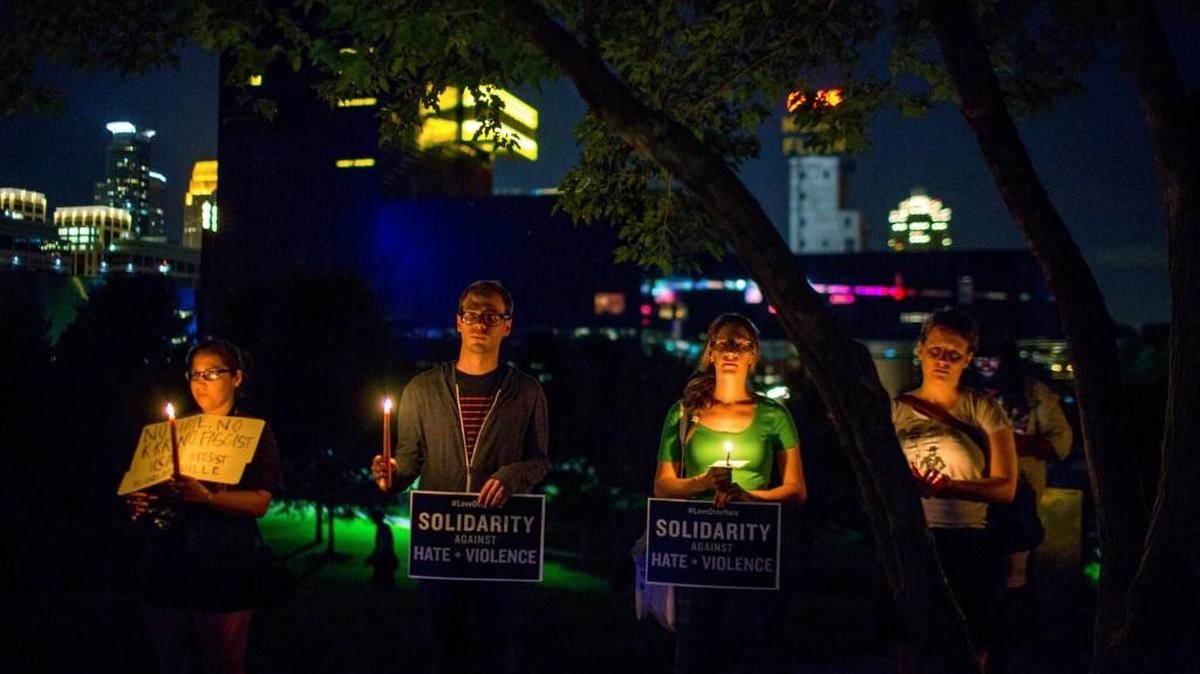 People stand atop a hill for a candlelight vigil in solidarity with Charlottesville, Va., counter-protesters at Gold Medal Park in Minneapolis on Saturday night, Aug. 12, 2017.