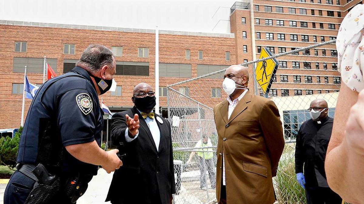 Rev. Vernon Howard, second from left, talks with a Veterans Administration police officer as Rev. Michael Brooks and Rev. Rodney Williams listen on July 1. The three were told they were not allowed to have an unplanned press conference as Veterans Affairs Secretary Robert Wilkie visited Kansas City.