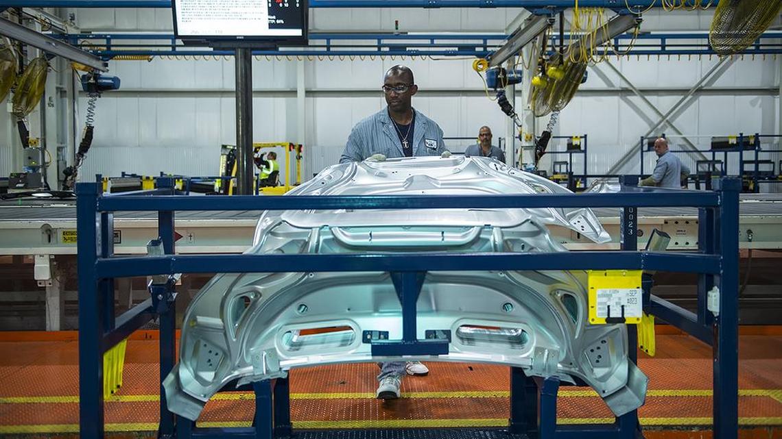 A worker at Ford’s Claycomo assembly plant inspects parts for the Transit commercial van.