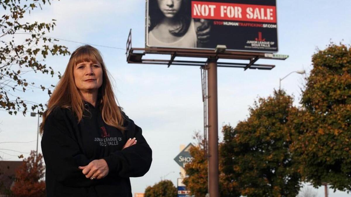 Dawn Stenberg, from the Junior League of Sioux Falls, S.D., stands near the group’s anti-human-trafficking billboard. Sex trafficking exists across the nation and more must be done to stop it.