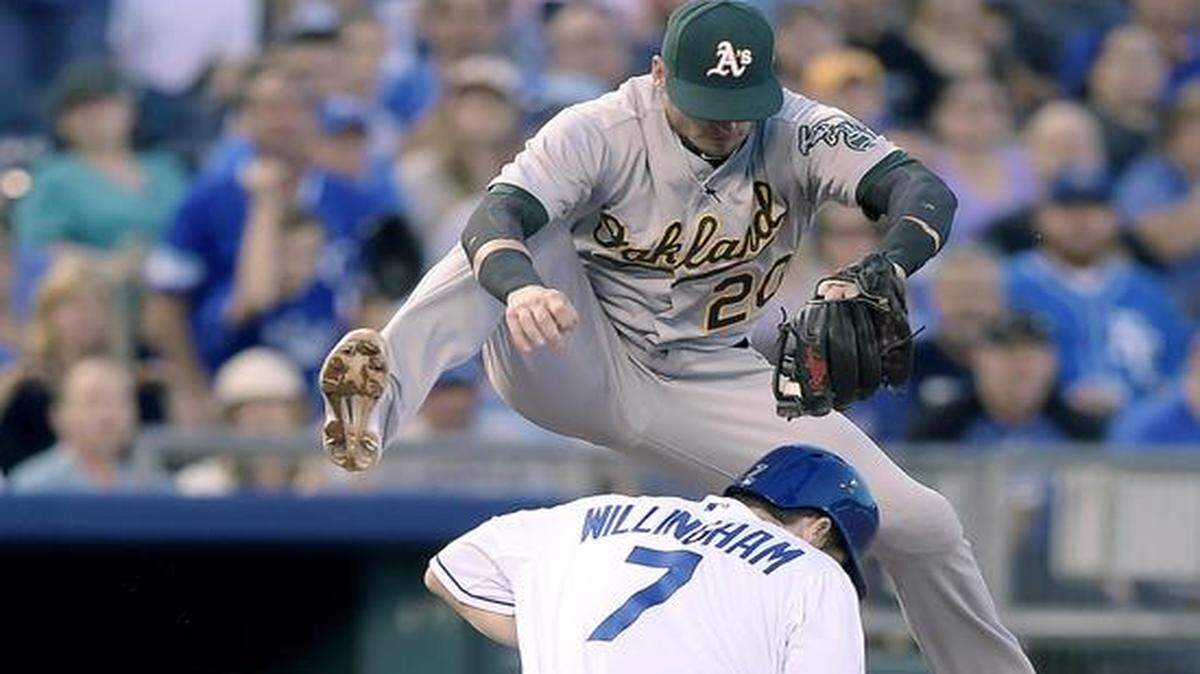 
Oakland Athletics third baseman Josh Donaldson took a high throw as the Royals’ Josh Willingham advanced to third on a throwing error in a game on Aug. 13.
