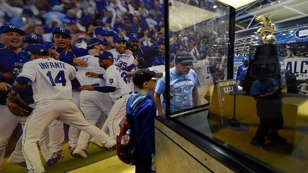 
Rodney Jenkins with Bret Brownlee, 10, both of Topeka, look at the American League Championship trophy during Friday’s Kansas City Royals Fanfest on Friday at Bartle Hall.
